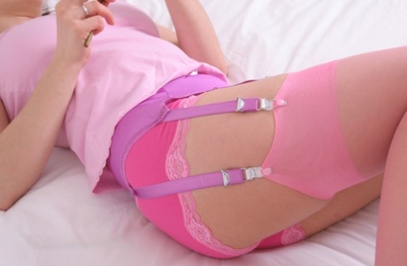 Caucasian female displays her garter belt while wearing soft pink nylons 22246945
