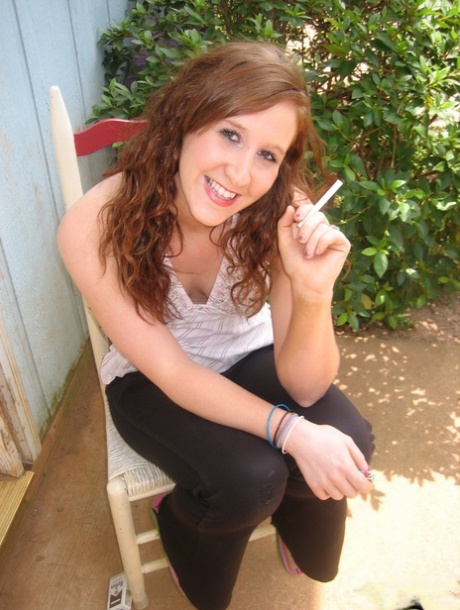 Young redhead flashes a boob while having a cigarette on a back porch 33301361